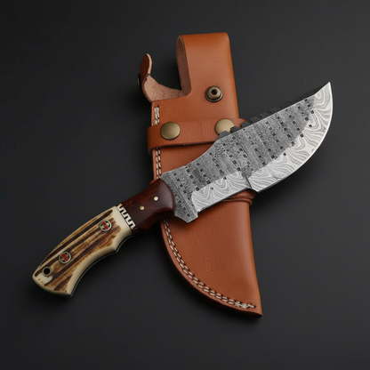 Handmade Damascus tracker knife with stag antler handle and dark wood bolster, dark charcoal studio background right facing