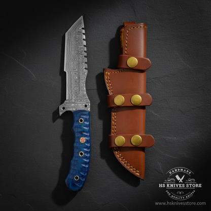 Damascus tracker knife with blue pakkawood handle and tan 3-strap leather sheath displayed vertically on dark slate luxury background