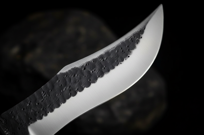 Close up macro shot of D2 steel Bowie knife blade showing hammered spine texture contrasting with mirror polished edge