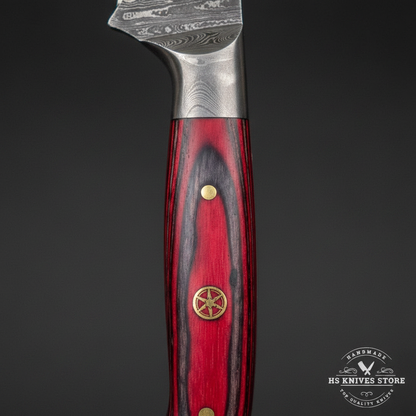 Macro view of red crimson dyed hardwood handle with layered scales brass pin and decorative brass medallion rosette on Damascus skinning knife