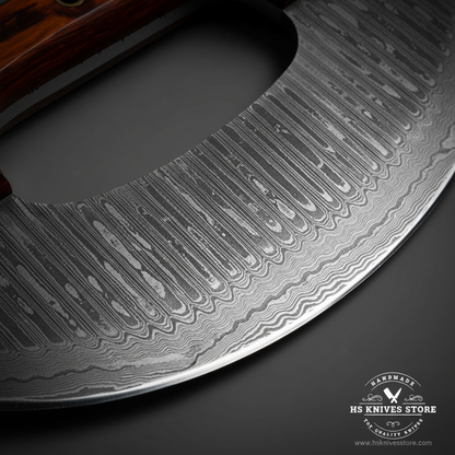 Close-up macro of Damascus steel ulu knife blade showing bold vertical ladder Damascus pattern and polished curved cutting edge