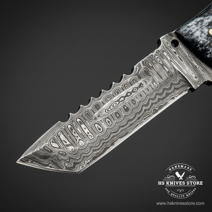 Macro close-up of Damascus steel tanto skinner knife blade showing bold flowing wavy pattern serrated spine section and angled tanto tip