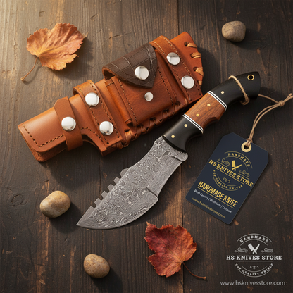 Damascus tracker knife two-tone micarta rosewood handle flat lay dark rustic wood with HS Knives Store hang tag autumn leaves