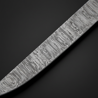 Damascus steel fillet blade close-up showing flowing layered Damascus pattern and sharp pointed tip