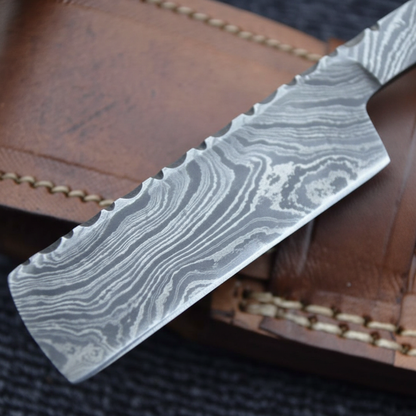 Macro detail of hand-forged Damascus steel blade showing layered pattern on straight razor