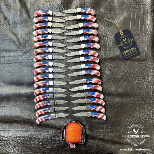35 Damascus pocket knives USA flag handles herringbone fan pattern flat lay with HS Knives Store hang tag on dark crocodile leather