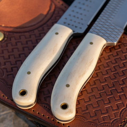 Macro detail of the same pale bone handles, pins, and lanyard holes on the Rasp Tool Steel knife pair