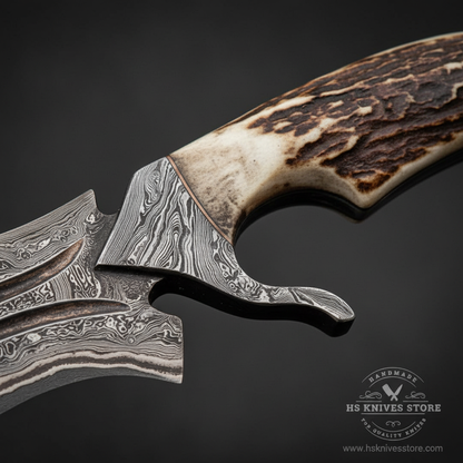 Close-up macro of natural stag handle with warm brown deep natural texture and Damascus steel integral guard with downswept quillon