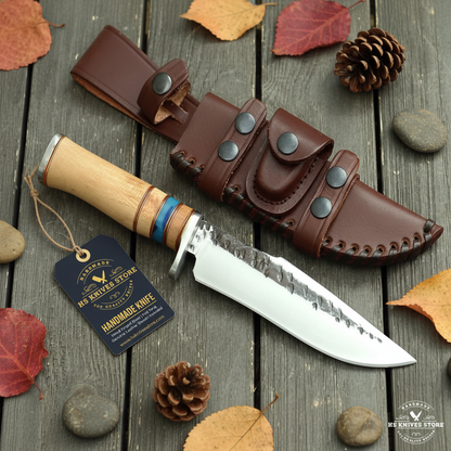 Hand forged hunting knife hidden tang stacked handle flat lay on dark rustic wood with HS Knives Store hang tag attached autumn leaves