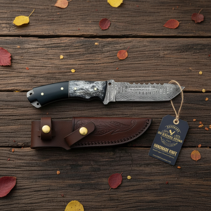 Damascus tanto skinner knife flat lay with micarta bone handle hang tag and brown leather sheath on dark rustic wood with autumn leaves