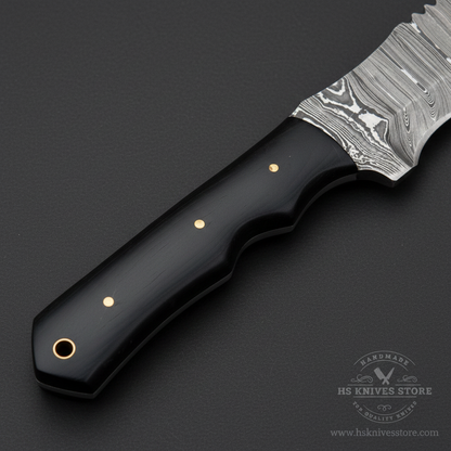 Close-up of black Micarta and wood scales, brass pins, finger grooves, and lanyard hole