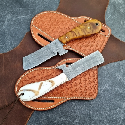 Back and reverse view of both full-tang Damascus Bull Cutter Knives with epoxy resin handles and separate leather sheaths