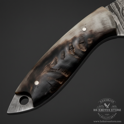 Close-up macro of natural ram horn handle with smooth dark charcoal surface subtle grain and two silver pin rivets on Damascus skinner knife