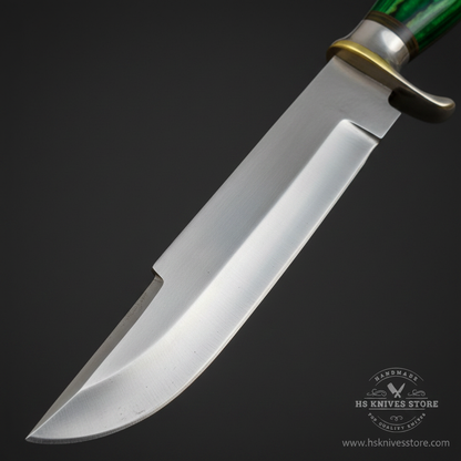 Close-up macro of D2 steel Bowie blade showing polished satin finish false edge on spine and brass clip quillon silver crossguard