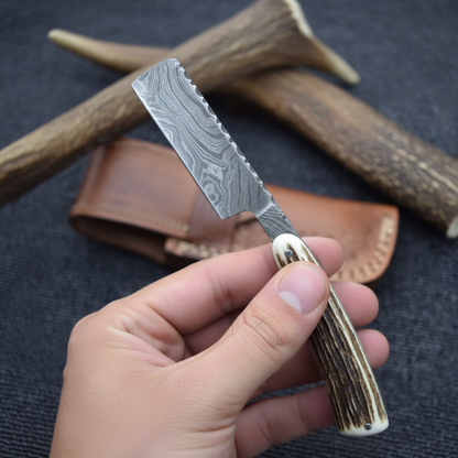 Gentleman holding handmade Damascus steel straight razor with natural antler handle lifestyle shot