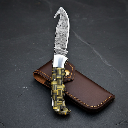 Damascus folding knife vertical luxury slate background blade open pointing upward