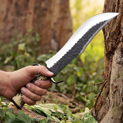 Hunter hand gripping D2 steel Bowie knife with antler handle and black D-guard outdoors forest background lifestyle photography